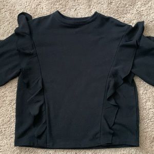 Black ruffle pull over top.